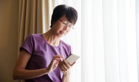 asian woman on smartphone at home
