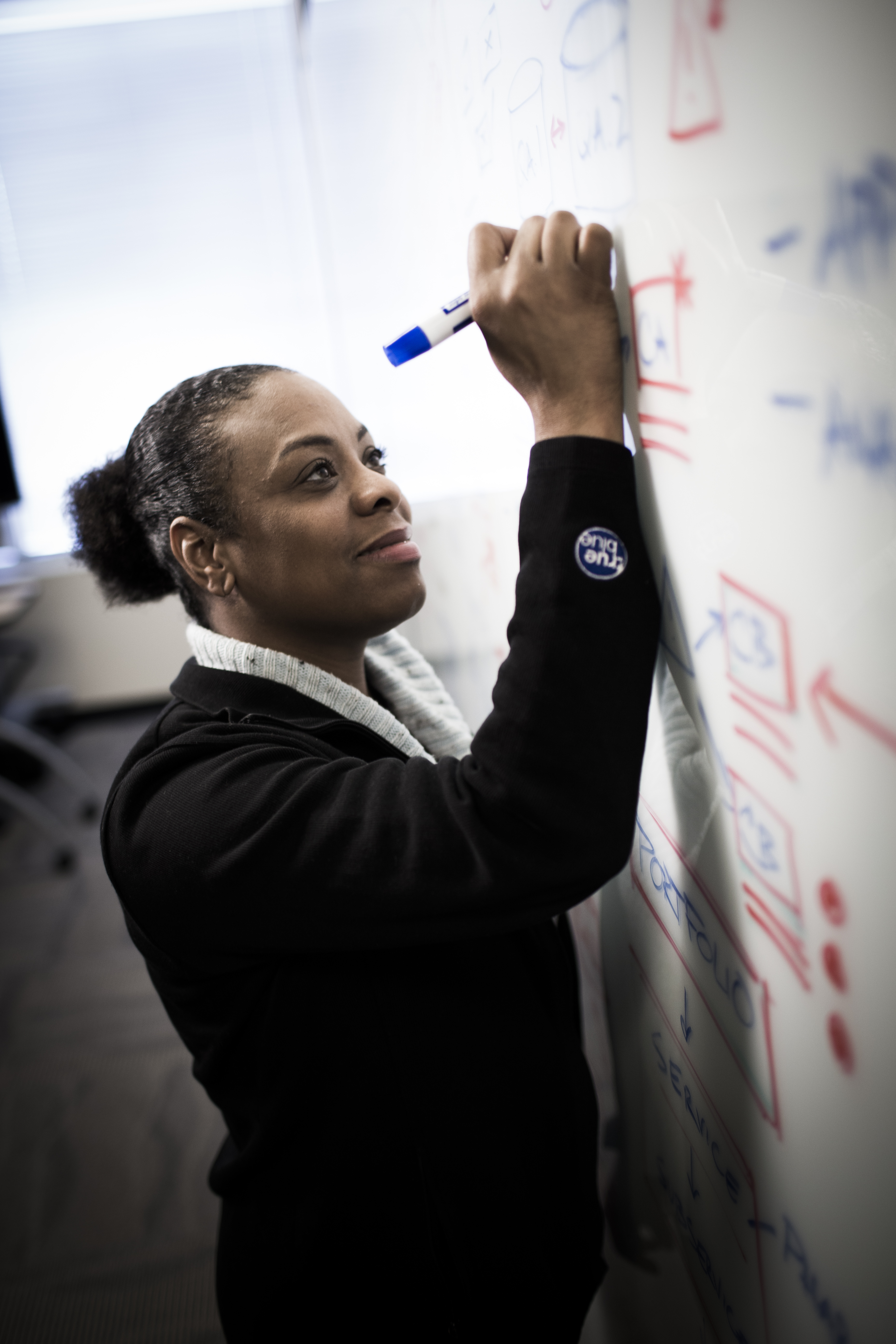 Woman writing on whiteboard
