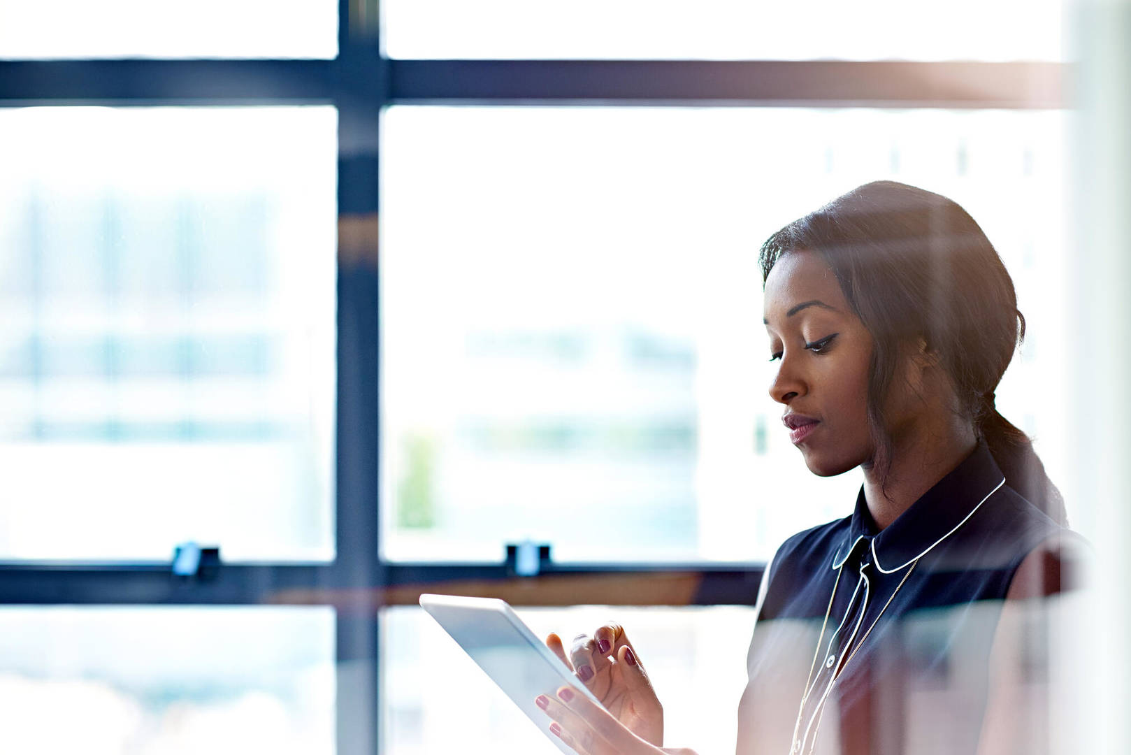 Young, Black, female employee looks at a clipboard
