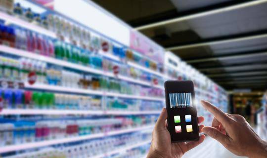 consumer scanning products on smartphone in store