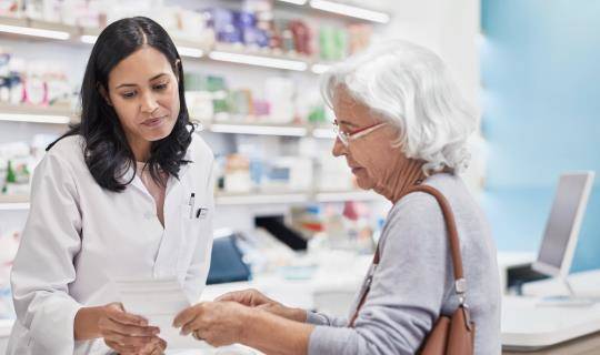 female pharmacist with elderly female patient