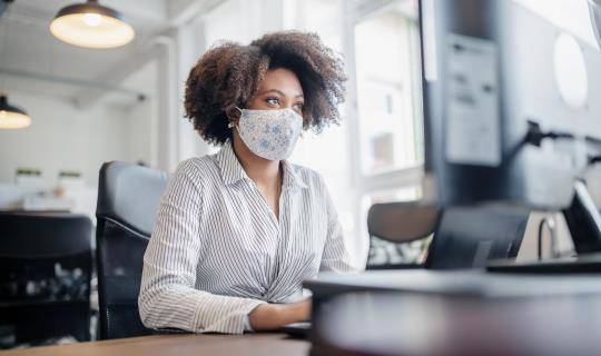 woman with mask at computer
