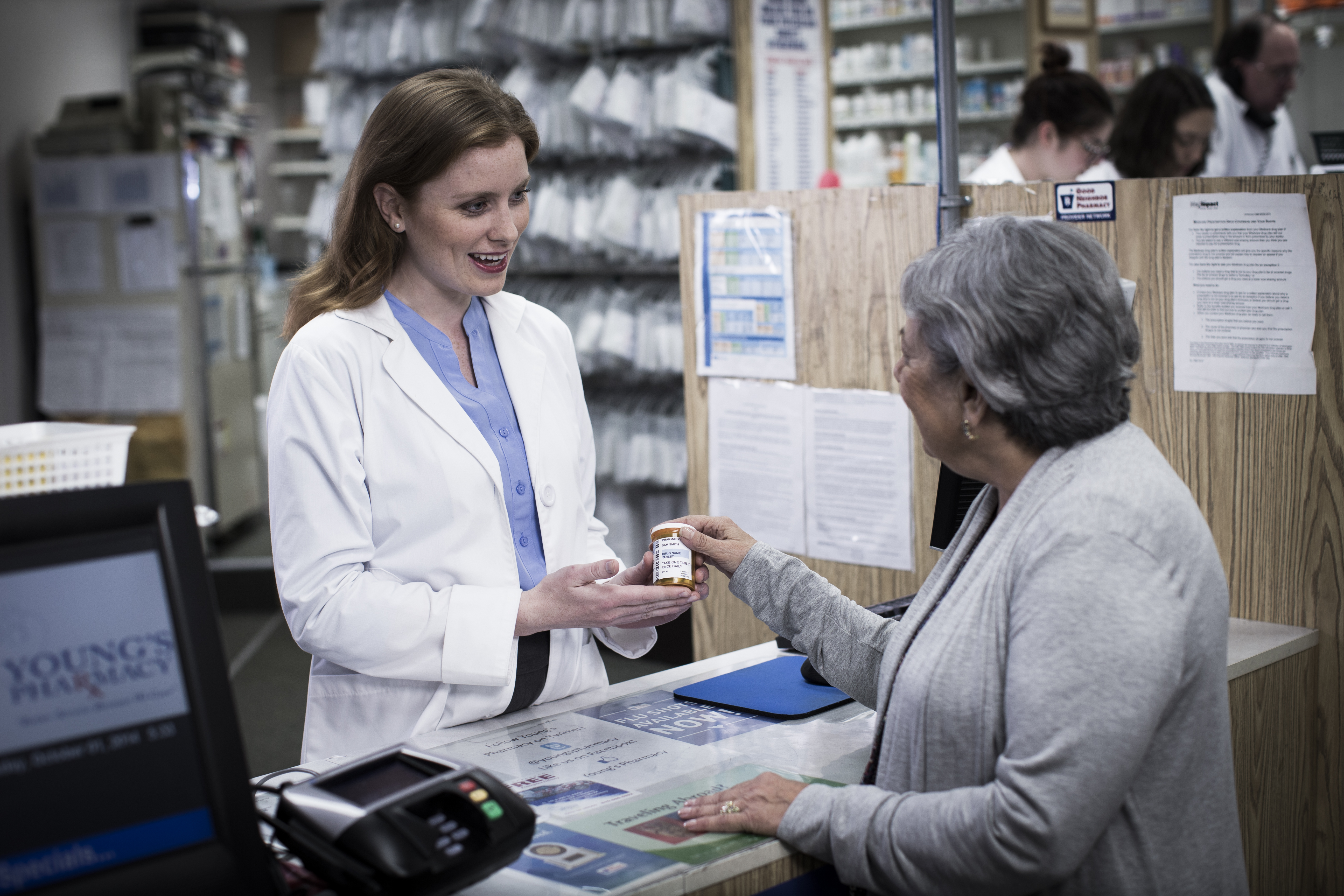 Pharmacist helping customer at counter