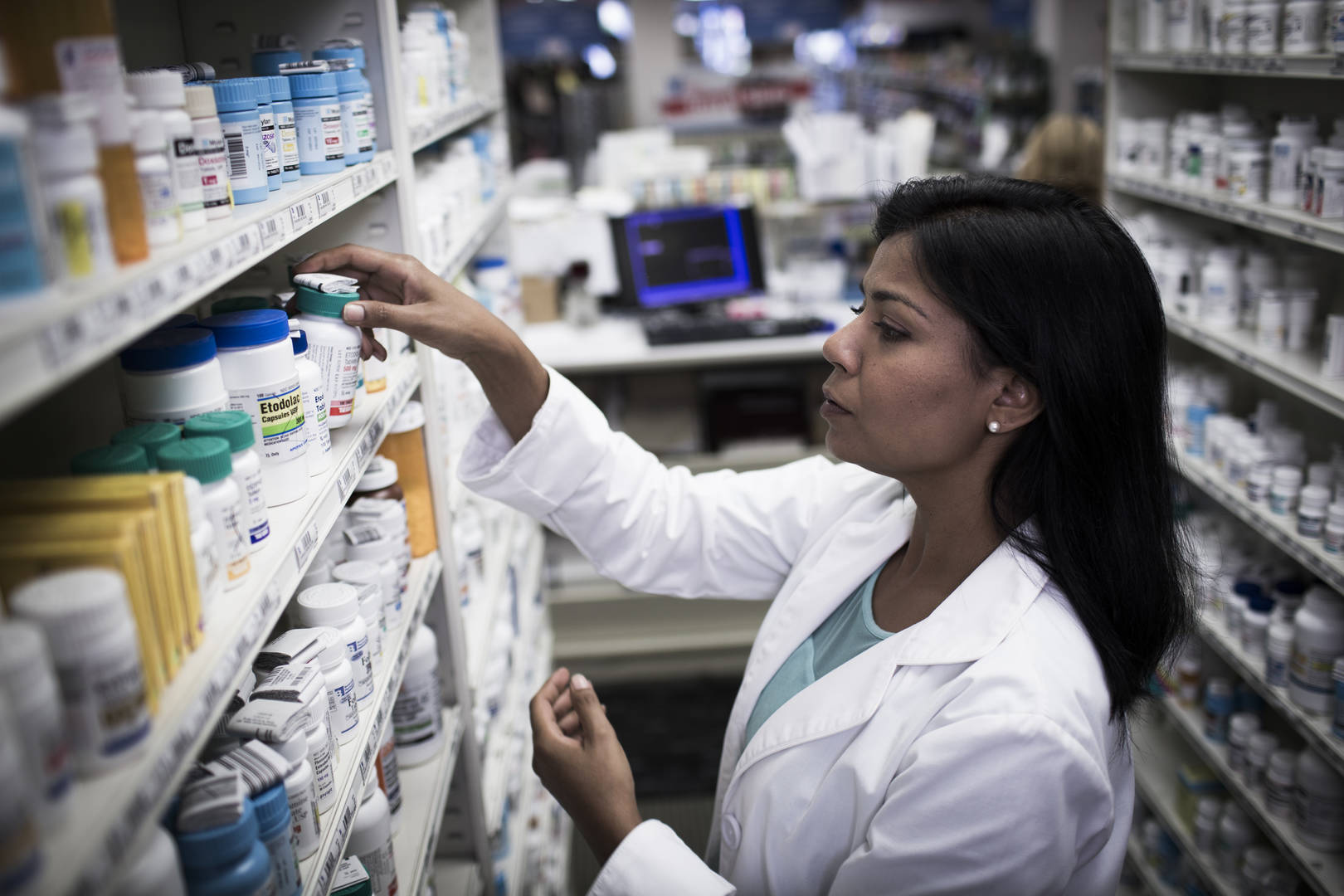 Pharmacist stocking bottles