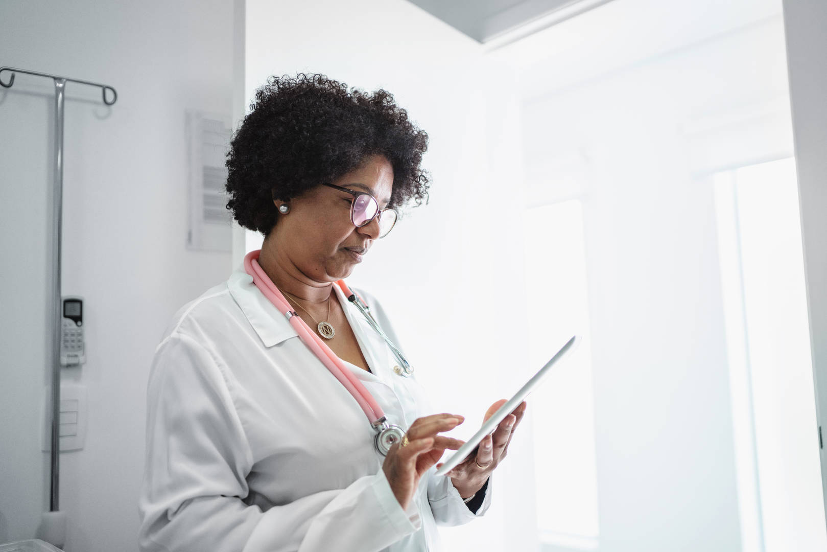 Black female doctor looks at iPad