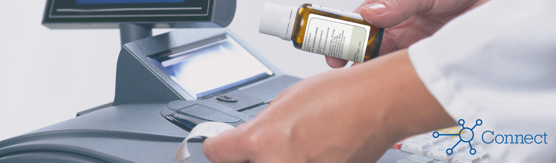 A pharmacist ringing up a prescription at a cash register