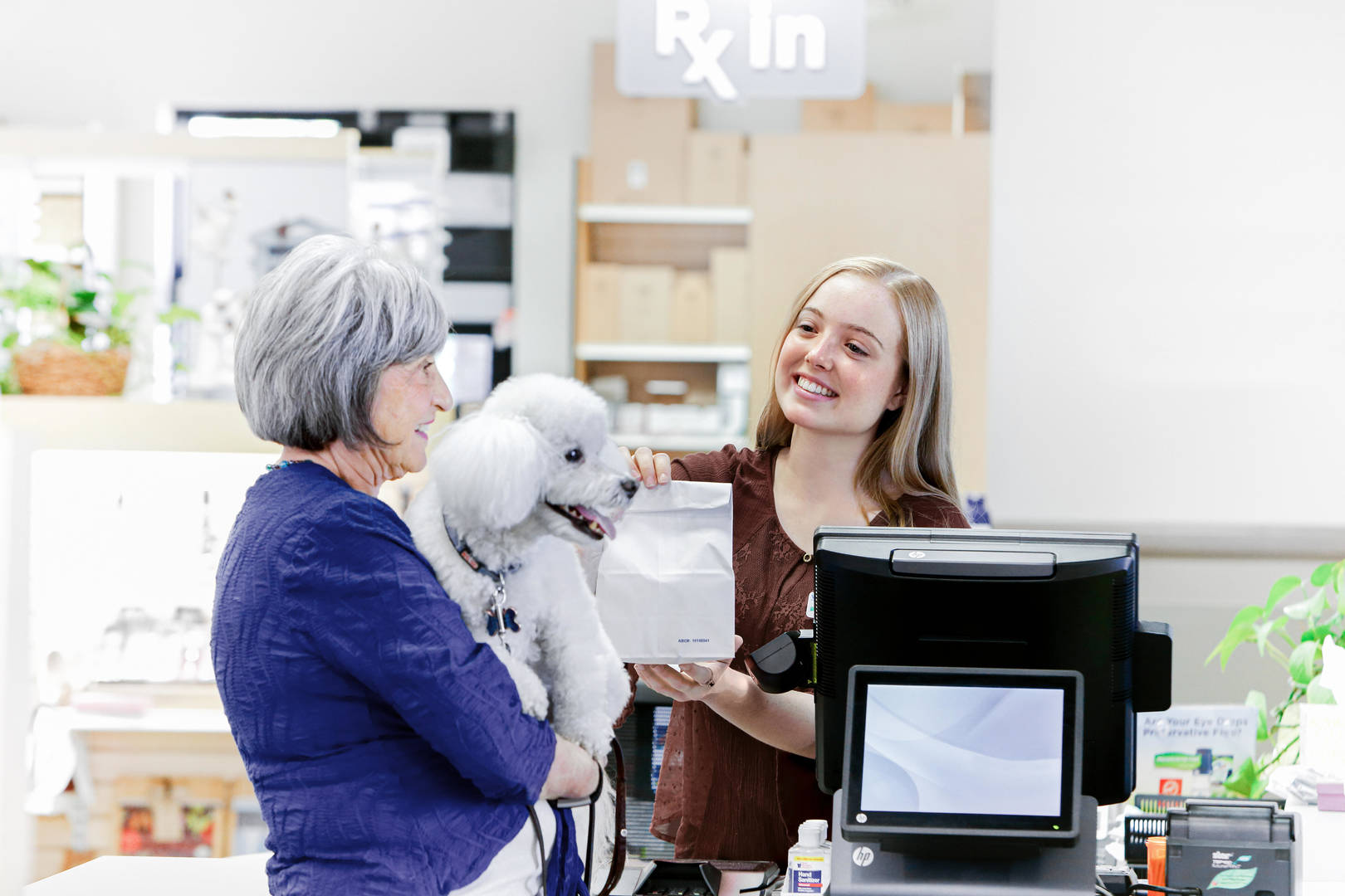 Cashier at vet office with woman with dog