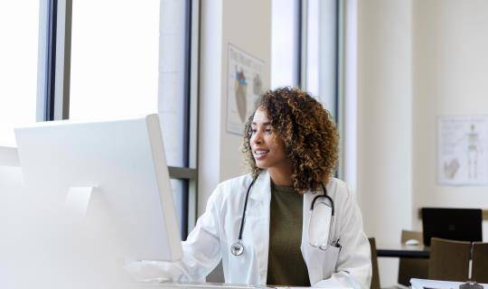 Female doctor at computer in office