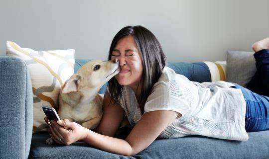 Asian woman texting with dog
