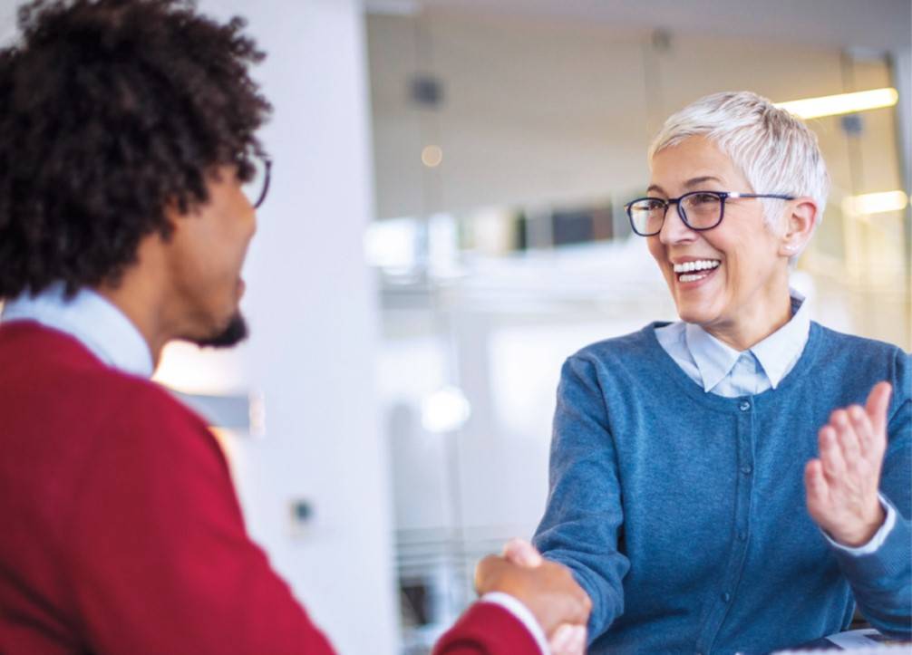 Woman and man shaking hands at job interview