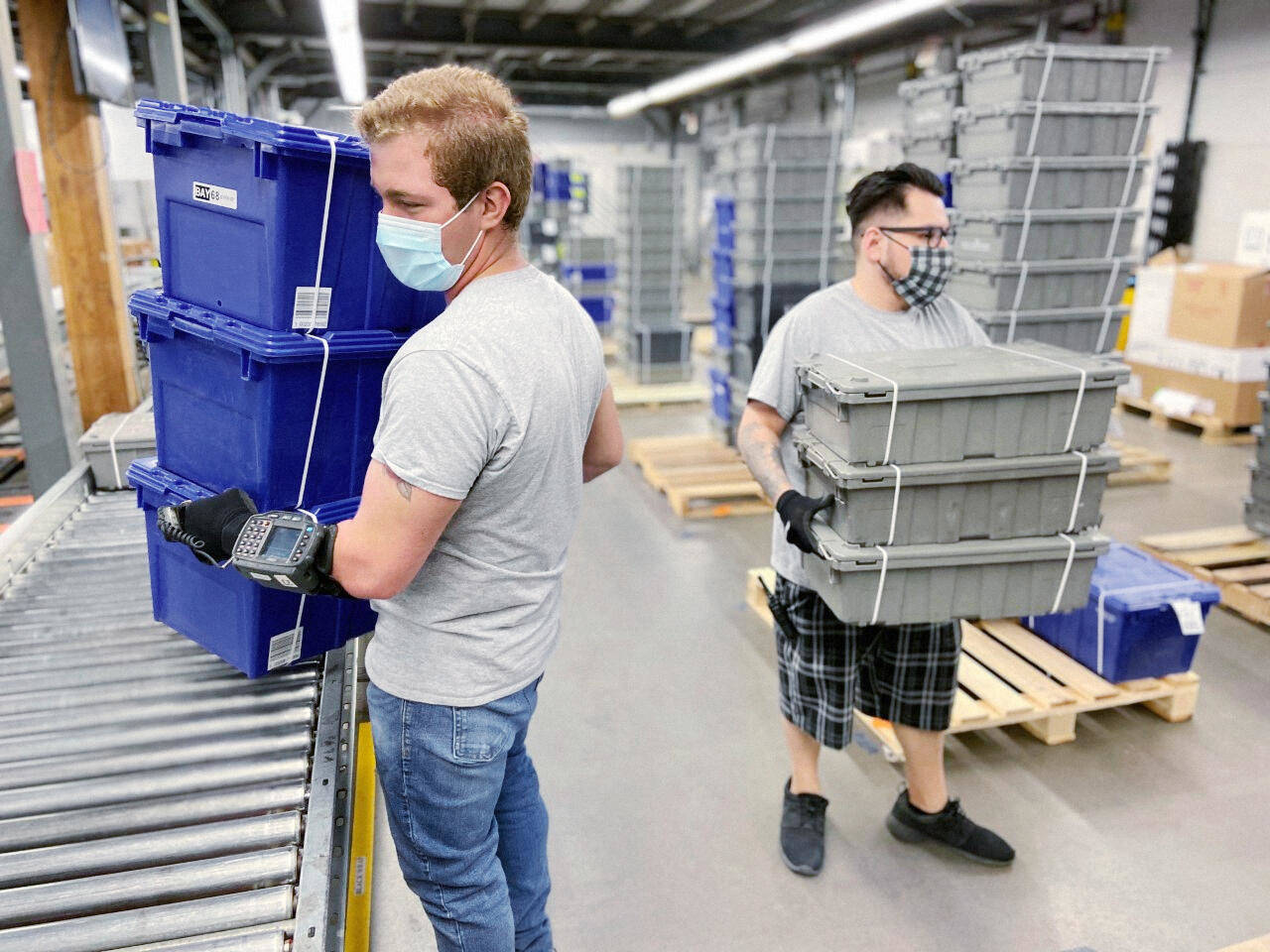 Workers carry totes at a DC