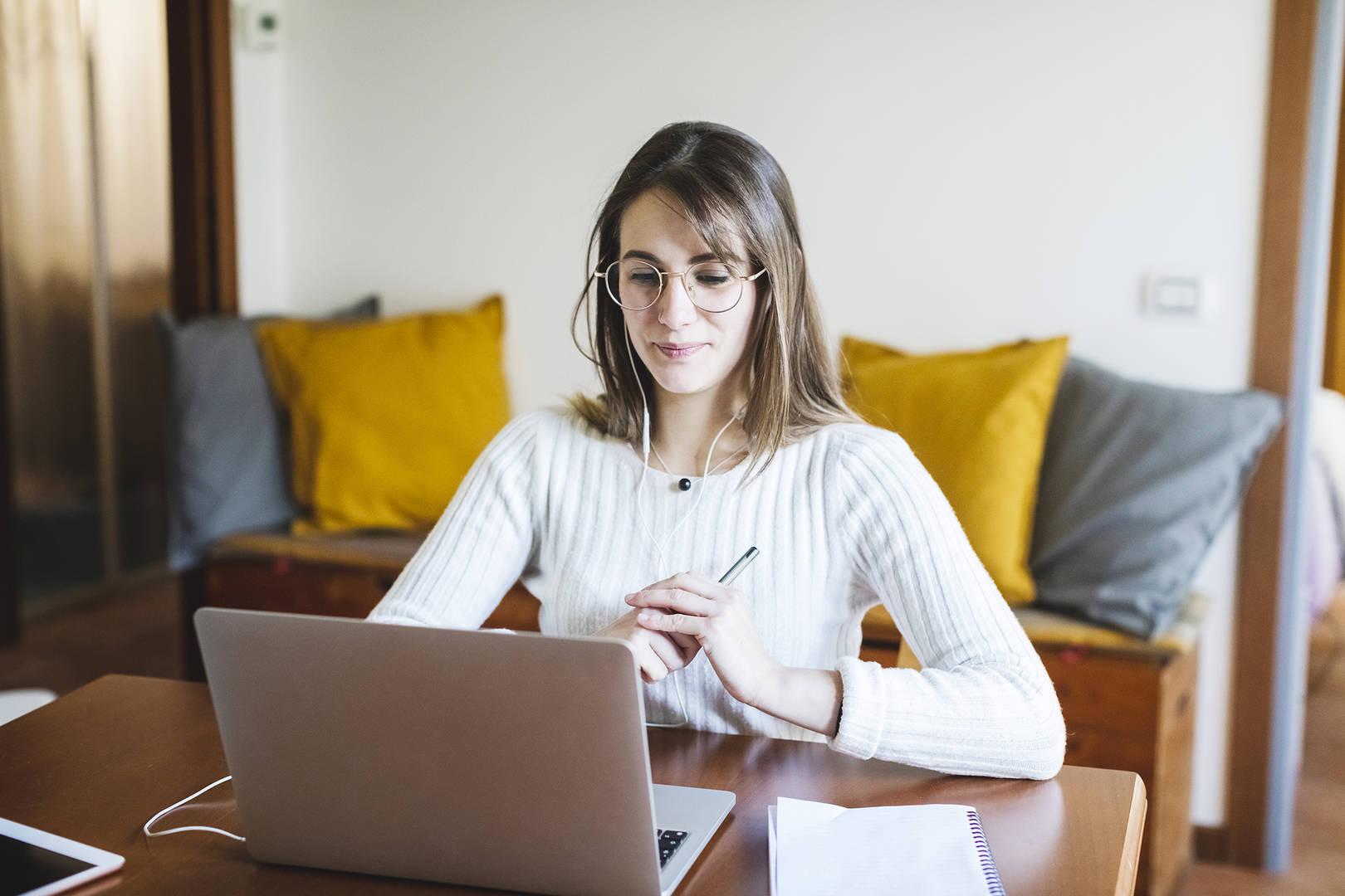 a young woman looks at a computer while at home